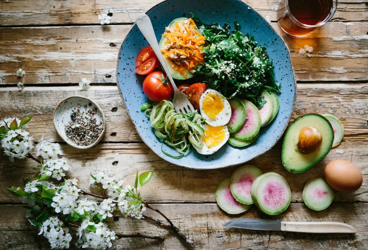 A breakfast bowl with egg, avocado and vegetables