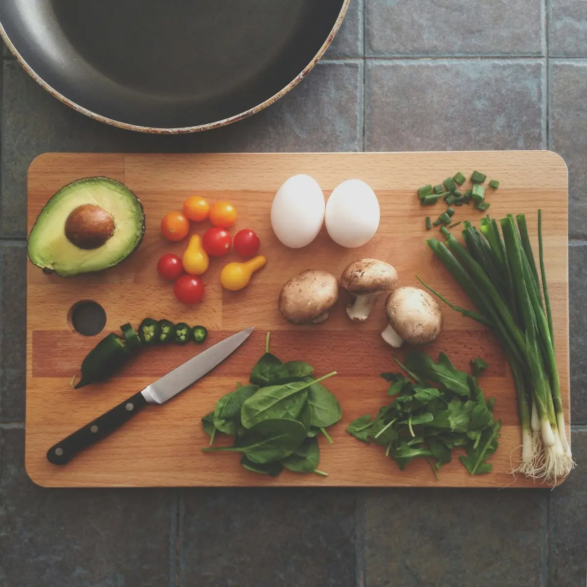 Vegetables and eggs on a wooden chopping board before cooking